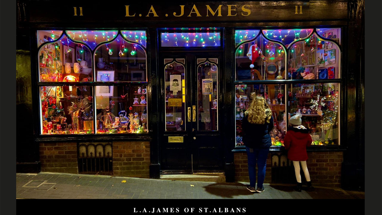 The lit shopfront of L. A. James of St Albans on George Street, with festive lights in the windows