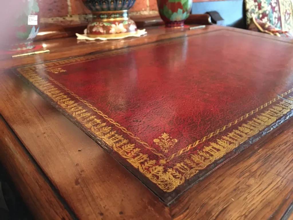 Close-up of a red leather desk top with gold-tooled decorative border